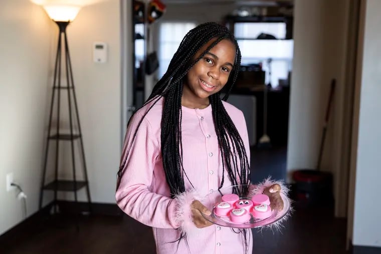 Makyla Linder, 12, posed for a portrait with chocolate-covered Oreos at her home in Philadelphia, Pa. on Sunday, December 6, 2020. Linder started her baking business, Dolci Desserts, during the pandemic.