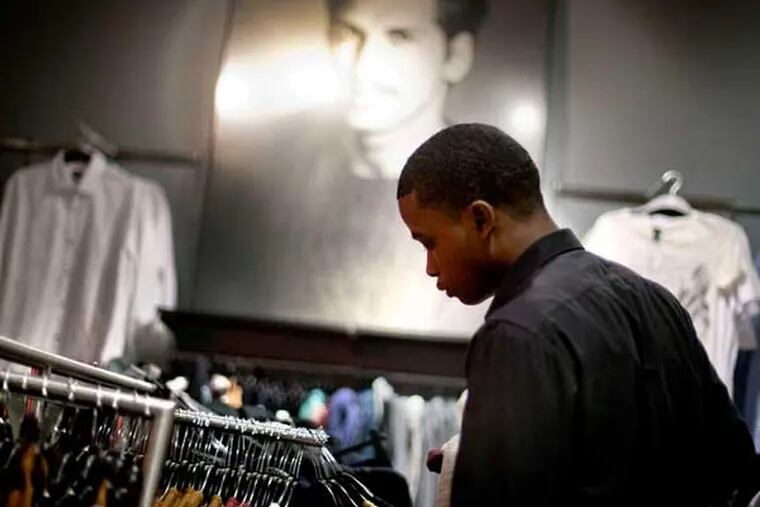 Dominic Plummer of Atlanta shops in an H&M store. A survey shows Americans have become more frugal since 2008. (David Goldman / Associated Press)