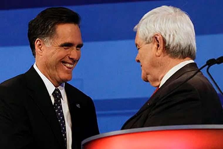 Republican presidential candidate, former Massachusetts Gov. Mitt Romney shakes hands with former House Speaker Newt Gingrich after a Republican presidential debate in Sioux City, Iowa, Thursday, Dec. 15, 2011. (AP Photo/Eric Gay)