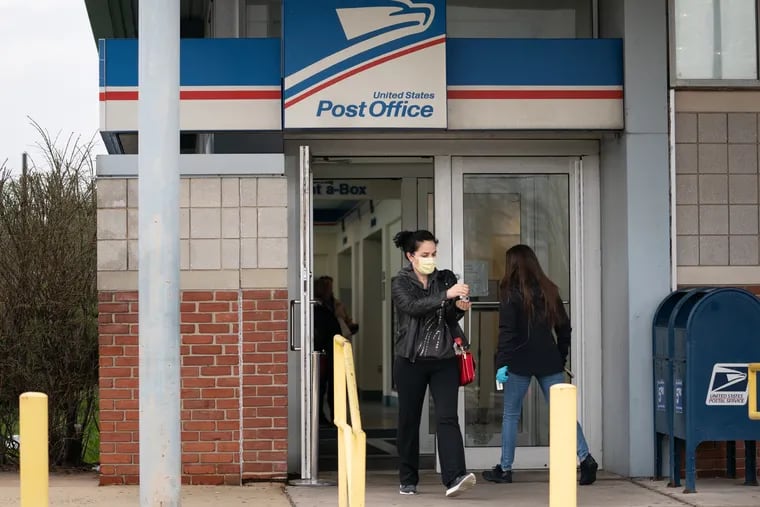 A woman uses hand sanitizer after leaving the Bustleton Post Office.