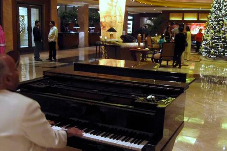 Music froma piano player fills the lobby of the Taj Mahal hotel, which reopened one of its towers yesterday. Other partsof the hotel remain damaged after last month&#0039;s terrorist attacks.