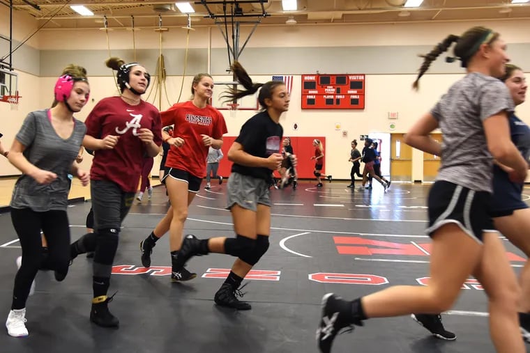 The Kingsway girls' wrestling team warms up before practice. "“These girls are athletes,” boys coach Mike Barikian said. "We have standout field hockey players, softball players, lacrosse players. But they are getting the wrestling ‘bug.’ "