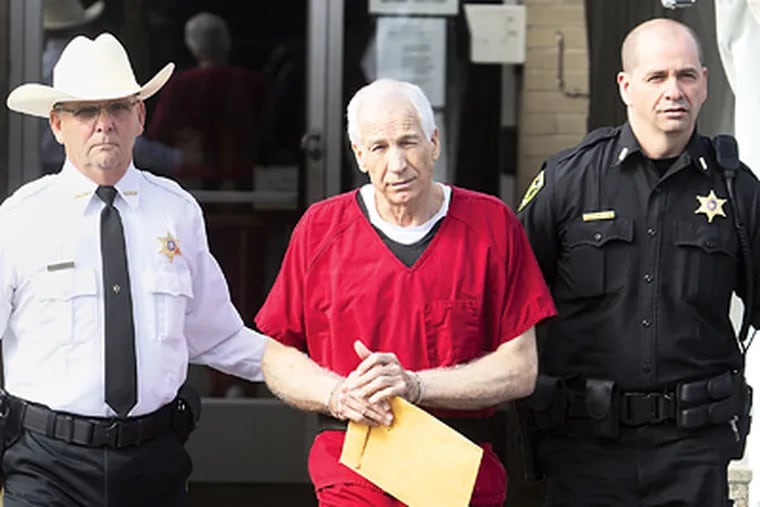 Jerry Sandusky is escorted from the Centre County Courthouse by Sheriff Denny Nau (left) and Deputy Todd Weaver after sentencing. ED HILLE / Staff Photographer