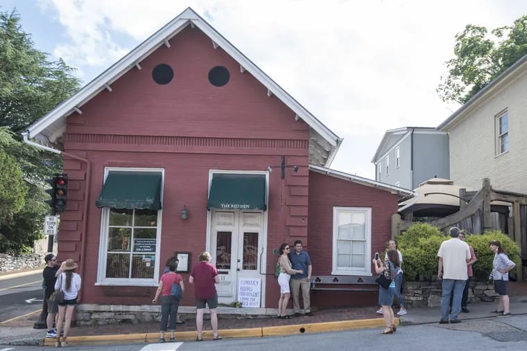 Passersby gather to take photos in front of the Red Hen Restaurant in Lexington, Va., on Saturday. White House press secretary Sarah Huckabee Sanders said Saturday in a tweet that she was booted from the Virginia restaurant because she works for President Donald Trump.