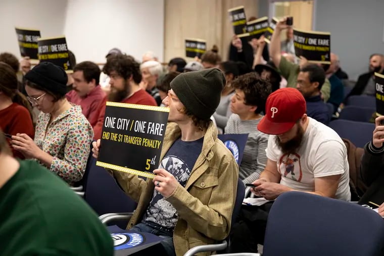 Jacob Long, 25, of Center City, Philadelphia Transit Riders Union, holds a sign to show support and the need to end the one dollar transfer fee when using SEPTA transportation during the SEPTA board meeting on Thursday, Feb. 27, 2020.