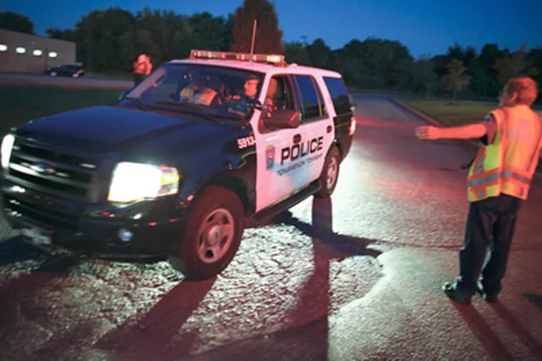 A police SUV passes a road block near the crime scene in Plymouth Township, Montgomery County, where Ofc. Bradley Fox was killed while pursuing a suspect near a bike path. Police closed off roads in the area as they searched for the suspect, who was later reported killed. (AP Photo/Joseph Kaczmarek)