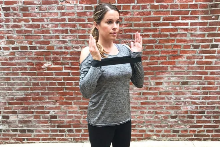 Using a black miniband for arm- and shoulder-strengthening exercises.