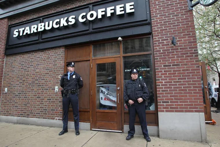 Police officers stand outside Starbucks at 18th and Spruce Streets Monday, April 16, 2018.