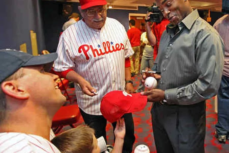 Wesley Rose (left), son Aden, and Wesley's dad Ray (center) get a few autographs from Phillies shortstop Jimmy Rollins.