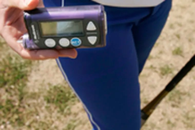 The sisters both use insulin pumps . Kelly, above, and Kristin frequently test their blood-sugar levels during games.