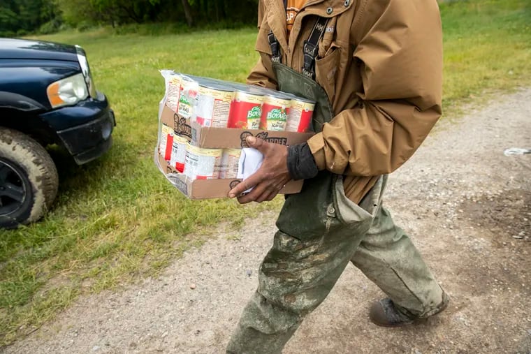 Un trabajador agrícola lleva un paquete de comida donada en el sector de Vineland, Nueva Jersey, en el mes de mayo.
