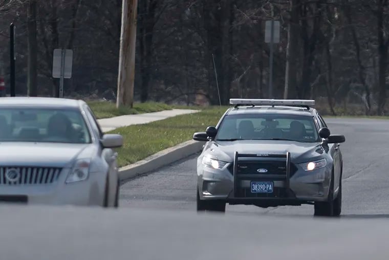 A State Police patrol car drives near Commerce Street in Carlisle, Pa.