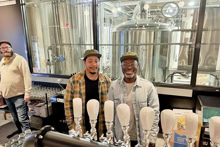 Brothers Richard (left) and Mengistu Koilor behind the bar at Two Locals Brewing Co., 3675 Market St., during the opening on Jan. 26, 2024.