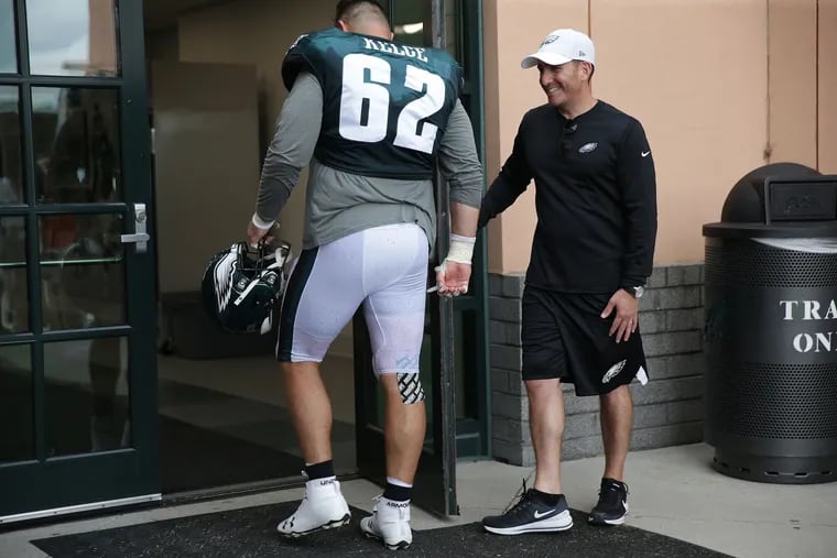 Eagles GM Howie Roseman (right), holding the door for center Jason Kelce at Eagles training camp last July.