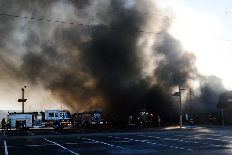 Firefighters respond to a fire at the Columbus Farmers Market on Tuesday, Nov. 18, 2014, in Springfield, Pa. (AP Photo/The Intelligencer, Carl Kosola)