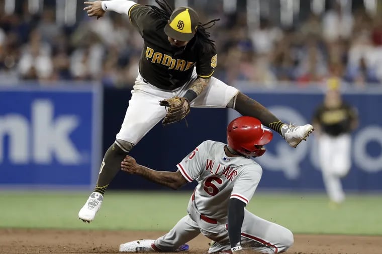 San Diego shortstop Freddy Galvis jumps over rightfielder Nick Williams after throwing to first to complete a double play during the eighth inning of  the Phillies' 2-0 loss to the Padres Friday.