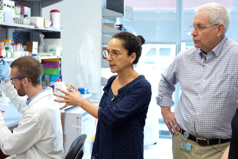 Children's Hospital of Philadelphia physicians Yael Mossé, center, and John Maris, right, are part of a research team getting up to $25 million to tackle 'undruggable' childhood cancers. Mark Gerelus, left, is a graduate student in Mossé's lab.