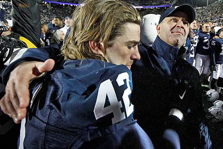 Penn State head coach Bill O'Brien (right) reaches to embrace injured senior Penn State linebacker Michael Mauti (left) as they celebrate a 24-21 overtime win against Wisconsin in an NCAA college football game in State College, Pa., Saturday, Nov. 24, 2012. (Gene J. Puskar/AP)