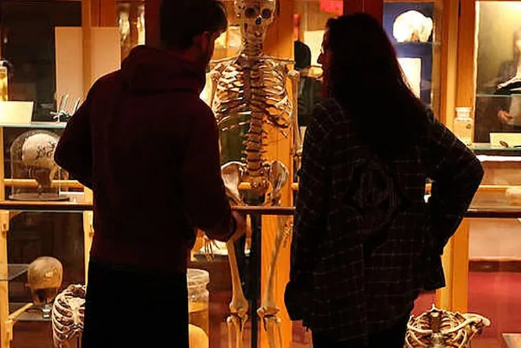 Adam Cogswell and Jennifer Hagopian, both from Parsonsfield, Maine, meeting one of their nighttime companions at the Mütter Museum last year. Hagopian says the night gave her "cool bragging rights." (STEVEN M. FALK / Staff Photographer)