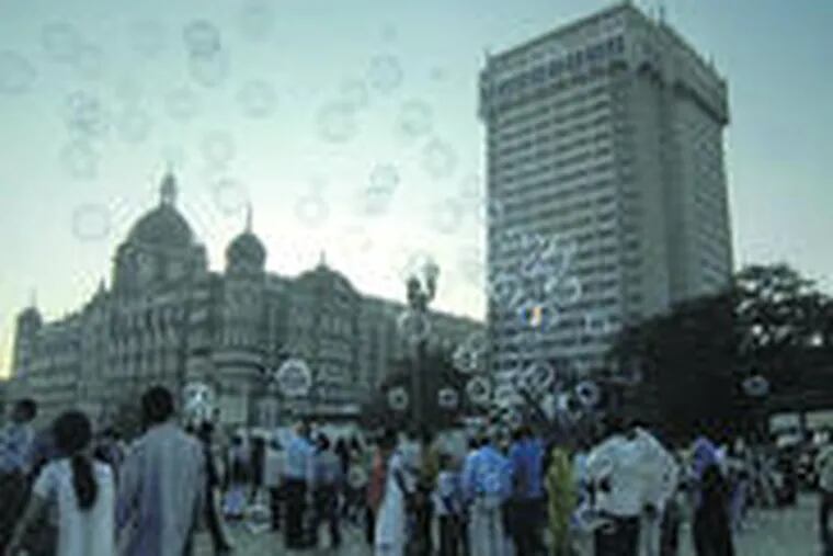 Soap bubbles lent a happier air in front of Mumbai&#0039;s Taj Mahal hotel, one of the sites attacked last month. Managers said the Taj and Oberoi hotels would partly reopen this weekend.