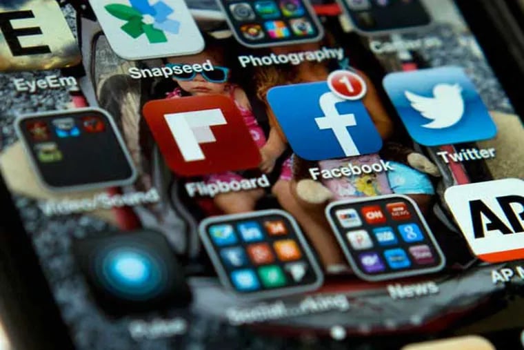 A view of an iPhone, showing the Twitter and Facebook apps among others. A new poll finds that teens are sharing more about themselves on social media. They’re also moving increasingly to Twitter to avoid their parents and the "oversharing" that they see on Facebook. (AP Photo/Evan Vucci)