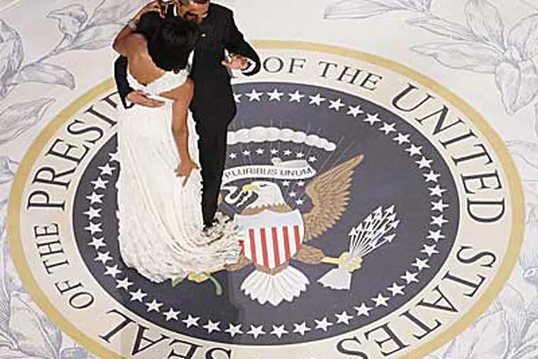 President Barack Obama gets caught in first lady Michelle Obama's dress train as they dance at the Commander in Chief Ball at the National Building Museum last night. (AP /Charles Dharapak)