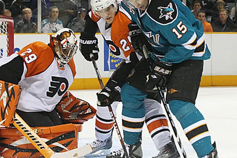 San Jose Sharks' Dany Heatley, right, shoots as Philadelphia Flyers' Matt Carle blocks in the first period of the Flyers 6-3 loss. Flyers goalie Ray Emery is at left. (AP Photo/George Nikitin)