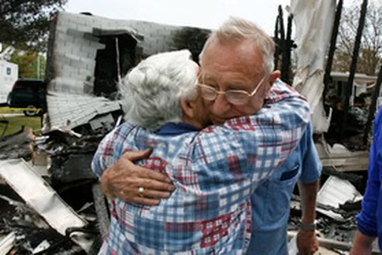 Lester Balkie gets a comforting hug from neighbor Edith Podchaski. Balkie&#0039;s home and one next door to it were destroyed by the fire as it swept out of the forest; others around them in Barnegat Township were spared.