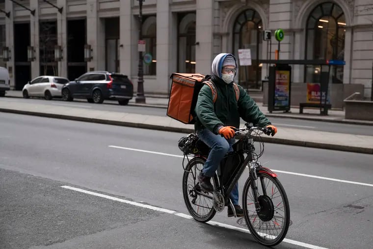 A masked food delivery worker for Caviar makes his way down Broad Street and Chestnut. Gig workers are eligible for Pandemic Unemployment Assistance, but many have reported problems getting access to the benefits.