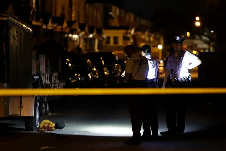 Philadelphia police officers investigate a shooting along the 5800 block of Trinity Street near 58th Street in the Kingsessing neighborhood in Southwest Philadelphia on Thursday, Sept. 30, 2021. A person was reported to have been shot in the neck.