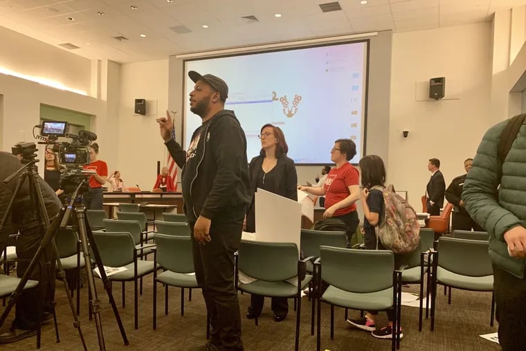 Julien Terrell, executive director of the Philadelphia Student Union, addresses the audience at the Philadelphia school board meeting after he and other activists, some of them students, shut the meeting down over a metal-detector policy.