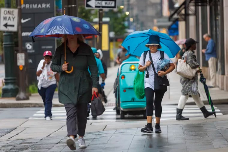 Walkers with umbrellas out along Market Street near Eighth in Center City on a dismal Monday. If it seemed like it had been raining since Saturday morning, it had. Yet, Ophelia's remnants spared the region of major impacts.