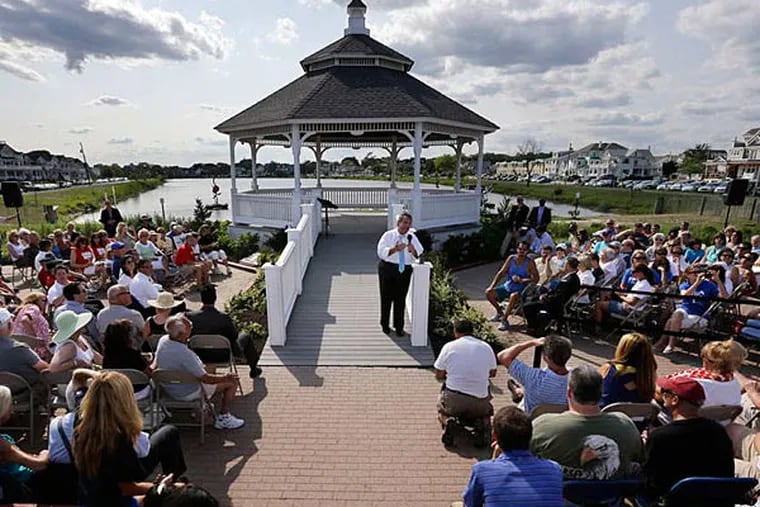 Gov. Christie continued his Shore talks with a town-hall meeting Wednesday at a gazebo near Belmar's beach. The crowd included many retired teachers and other state workers who held signs and wore shirts that said &quot;Our Pain, Christie's Gain&quot; - a play on the &quot;No Pain, No Gain&quot; title his staff has given this summer's push. (Mel Evans/AP)