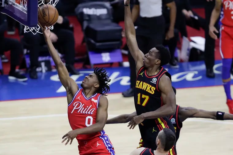 Sixers guard Tyrese Maxey scores past Hawks forward Onyeka Okongwu in the first quarter Sunday.