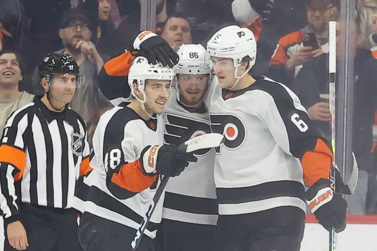 Flyers left wing Joel Farabee (center) celebrates his second period goal with teammates center Morgan Frost (left) and defenseman Travis Sanheim against the Arizona Coyotes on Thursday, January 5, 2023 in Philadelphia.