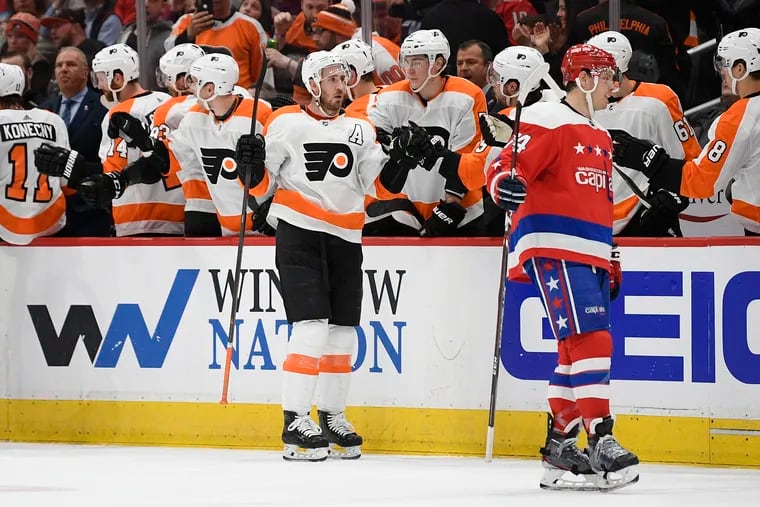 Philadelphia Flyers center Kevin Hayes (center) celebrates his goal as Washington Capitals defenseman John Carlson skates nearby during the second period.