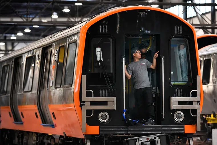 Employees work on rail cars for Boston's Orange and Red Line T fleets at CRRC in 2019 in Springfield, Mass. CRRC, the company manufacturing SEPTA's new rail cars, is under pressure from Congress, which sees it as anti-competitive and a security risk because it is owned by the Chinese government.