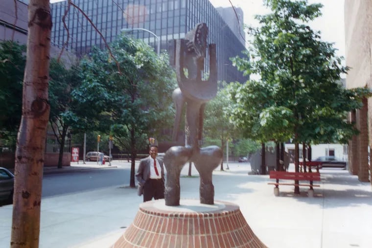 John Rhoden beside his public art sculpture "Nesaika" installed at the front entrance of the Afro-American Historical and Cultural Museum.