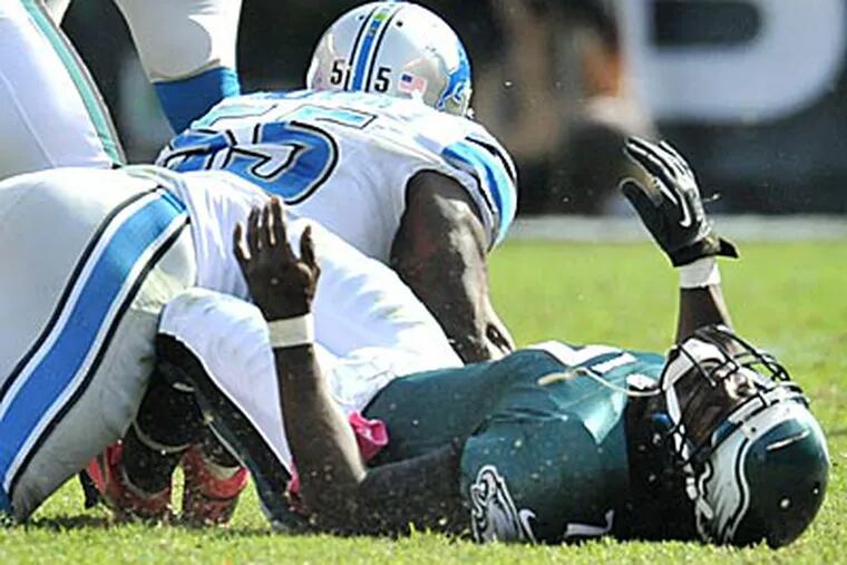 Michael Vick lands hard on his back after getting hit by Lions linebacker Stephen Tulloch. (Clem Murray/Staff Photographer)