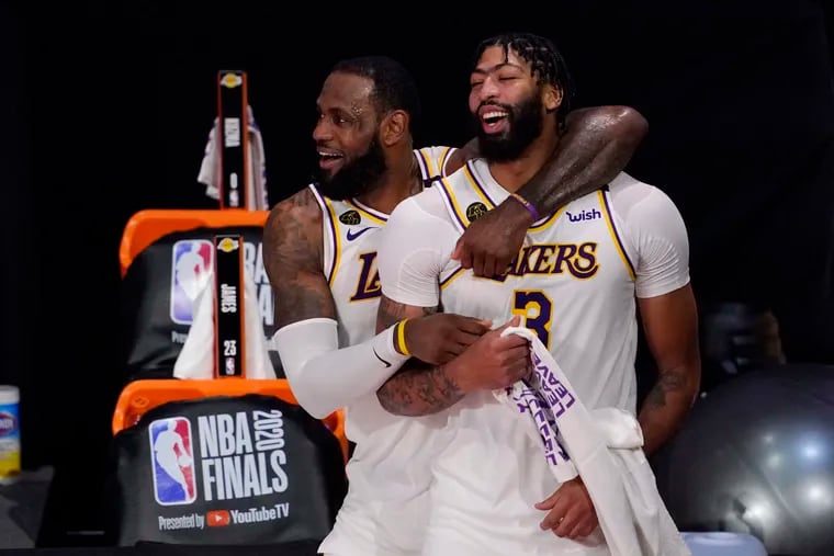 Los Angeles Lakers' LeBron James (23) and Anthony Davis (3) celebrate after the Lakers defeated the Miami Heat to win the NBA Finals on Sunday.