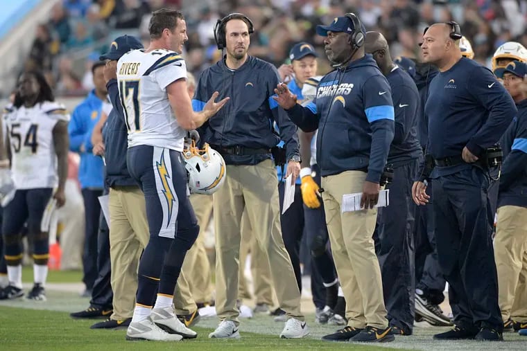 Philip Rivers, then with the Los Angeles Chargers, talks with head coach Anthony Lynn and offensive coordinator Shane Steichen (immediate right of Rivers) in 2019.