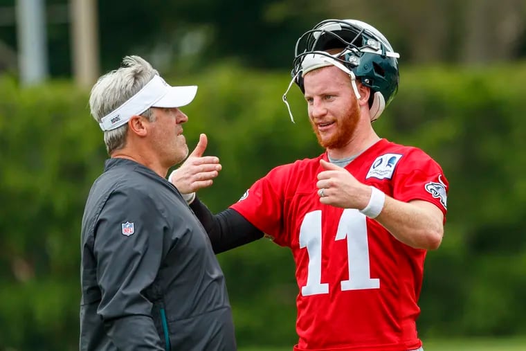 Eagles quarterback Carson Wentz, right, and Eagles head coach Doug Pederson talk things out during a practice.