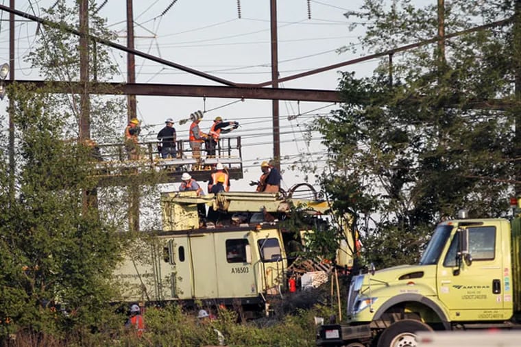 Workers repair Catenary wires at the scene of the crash. (STEVEN M. FALK / STAFF PHOTOGRAPHER)