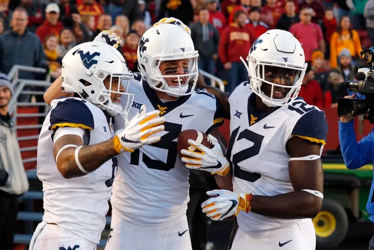 West Virginia wide receiver David Sills V, center, celebrates with teammates after catching an 18-yard touchdown pass during the first half of an NCAA college football game against Iowa State, Saturday, Oct. 13, 2018, in Ames, Iowa. (AP Photo/Charlie Neibergall)