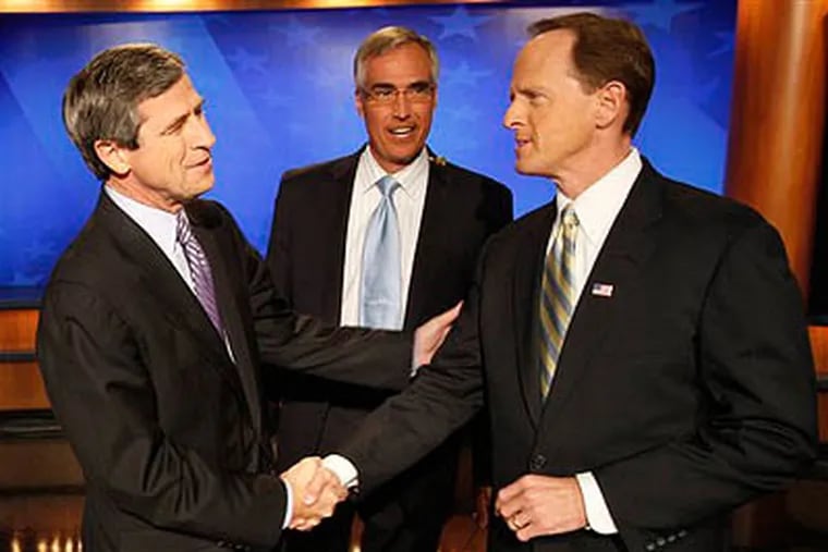 Pennsylvania Senate candidates Democratic Rep. Joe Sestak, D-Pa., left, and Republican Pat Toomey, shake hands in front of moderator David Johnson before a debate broadcast live from a television studio in Pittsburgh Friday, Oct. 22, 2010. (AP Photo/Keith Srakocic)