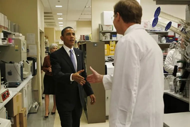 President Barack Obama is greeted by  Dr. Marston Linehan  as he tours an oncology laboratory at the National Institute of Health. Last night, the Obama administration unveiled the broad outlines of a proposal to overhaul the regulation of thousands of chemicals. (AP Photo / Gerald Herbert)