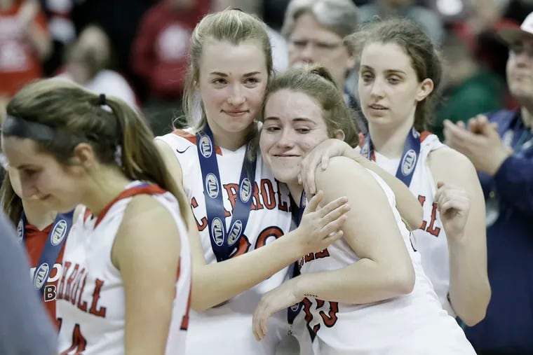 Archbishop Carroll # 20 Hope Syron hugs # 25 Bridget Hislop as # 22 Erin Sweeney looks on after Archbishop Carroll lost the Archbishop Carroll vs. Chartiers Valley H.S. PIAA Class 5A girls basketball state championship game at the Giant Center in Hershey, Pa. on March 23, 2019.