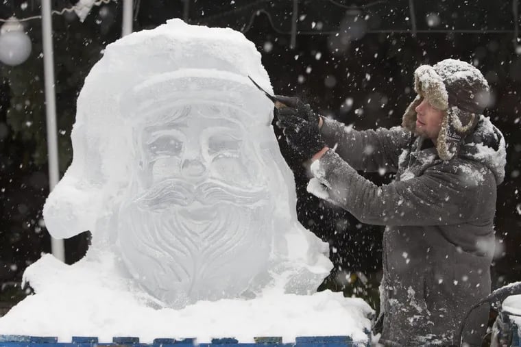 Ice sculptor Don Lowing carves a block of ice in the likeness of Santa Claus at Linvilla Orchards in Media earlier this month.