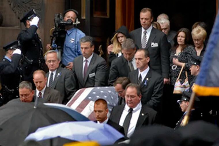 The family of Phila. Police Sgt. Stephen Liczbinski follows his casket from the Cathedral Basilica of SS. Peter and Paul. Throngs of officers from around the country gathered in the rain yesterday to pay tribute to a comrade gunned down while responding to a bank robbery last Saturday.