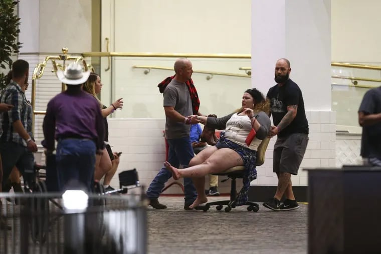 A wounded woman is moved outside the Tropicana during an active shooter situation on the Las Vegas Strip in Las Vegas Sunday, Oct. 1, 2017. Multiple victims were being transported to hospitals after a shooting late Sunday at a music festival on the Las Vegas Strip.